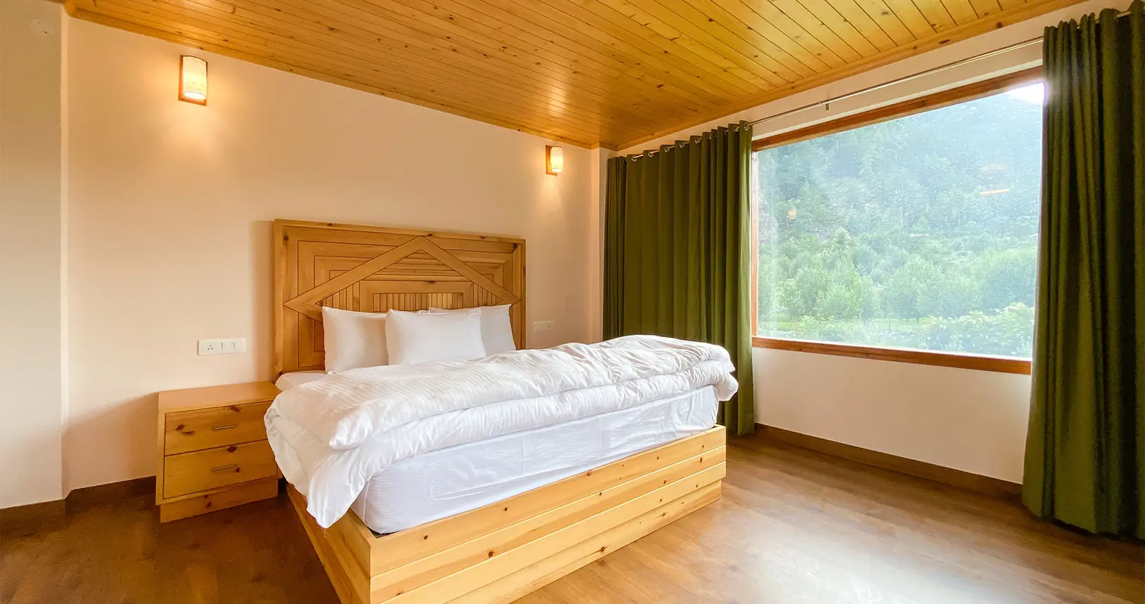 Bed and orchard view from family suite at Hotel Batseri, Sangla.