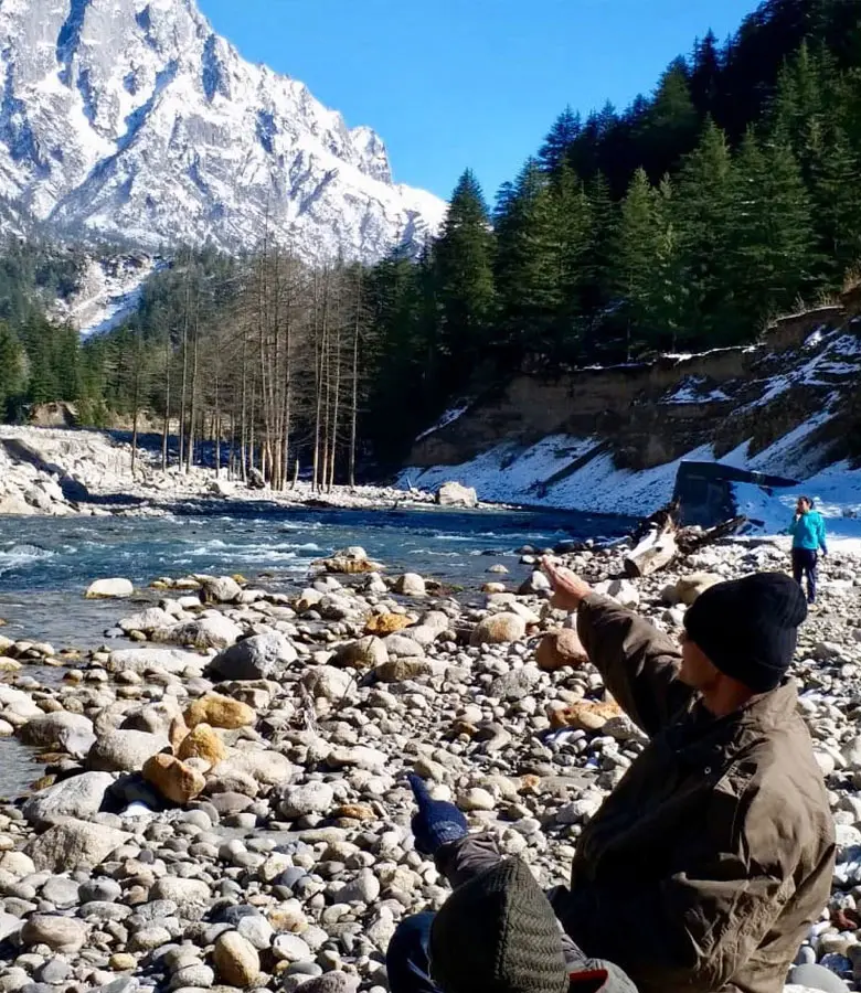 Guests enjoying activities in Sangla near Hotel Batseri, with snow-capped mountain peaks in the background.