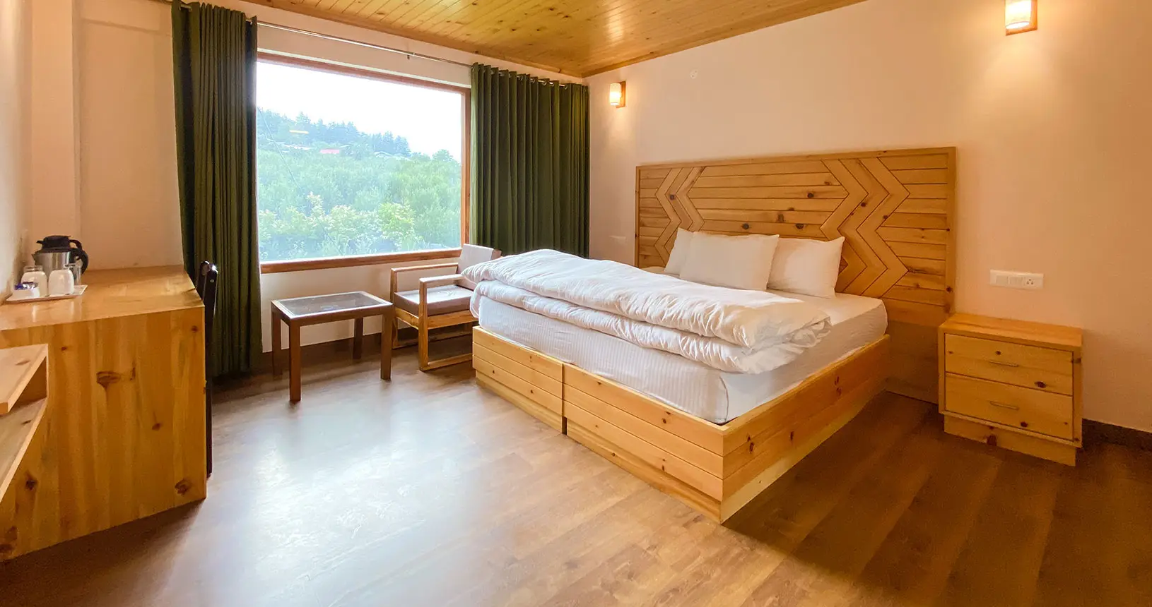Dining area, bed, and view from deluxe room at Hotel Batseri, Sangla.